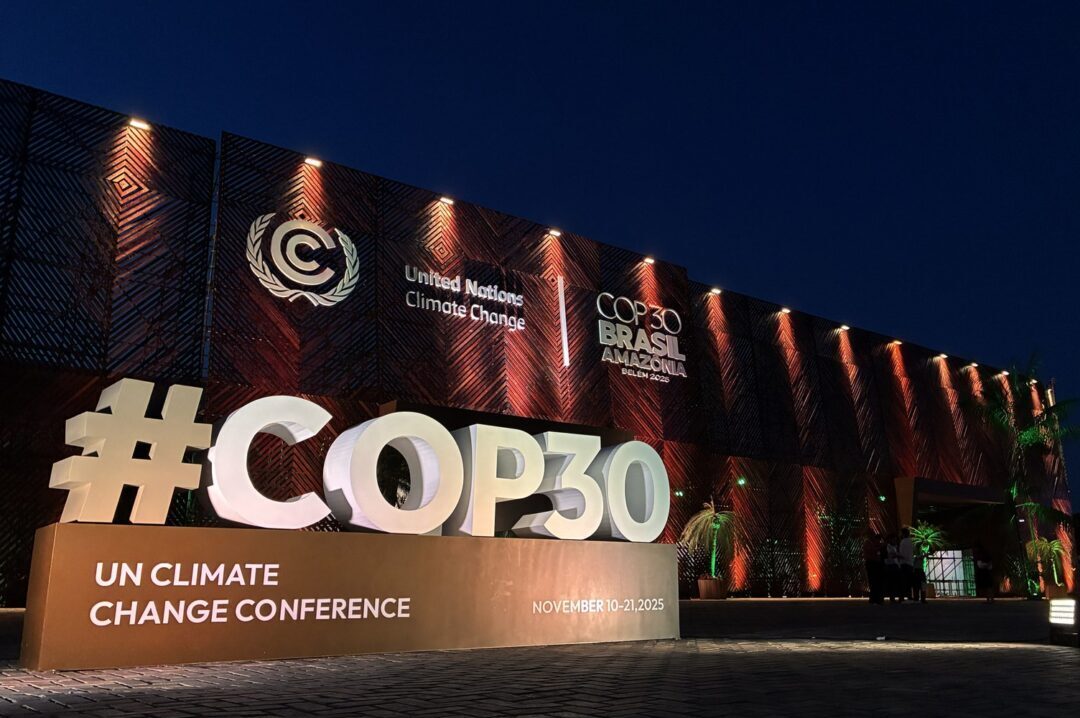 Fachada principal da COP-30 em Belém do Pará, Brasil, com letreiro iluminado e logotipo “UN Climate Change Conference”.